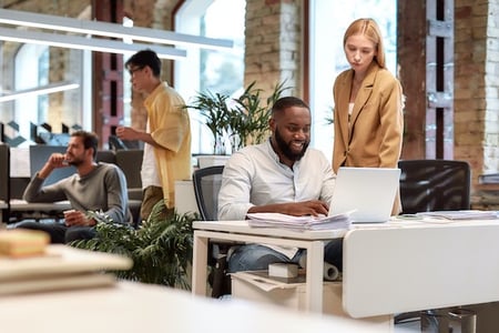 people in an office using a computer to browse for the fastest CMS